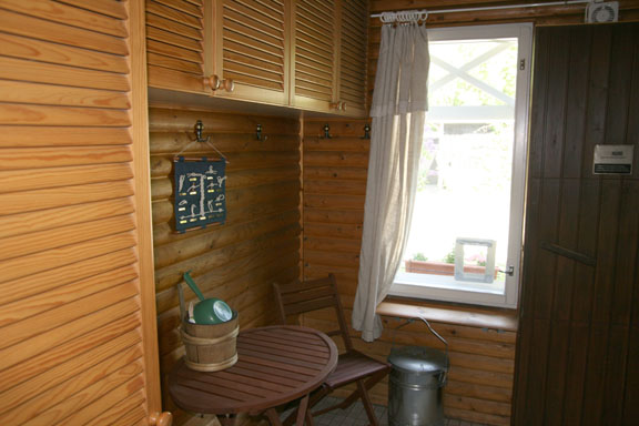 A wood-panelled room with a small table and a window.